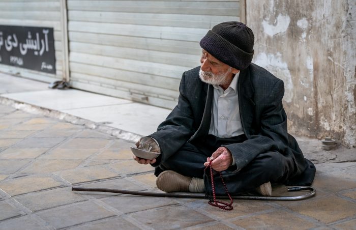 Old man destitute and homeless asks for alms in Yazd, Iran.