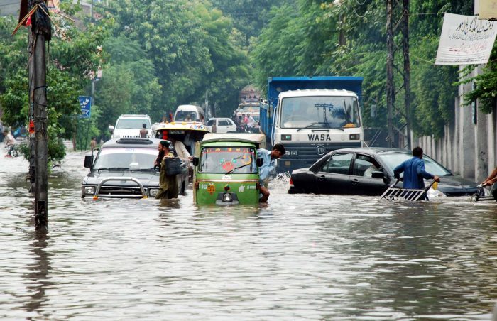 Vehicles and motorists pass through the flooded streets of a major city in Punjab as the rivers and canals are breached.
