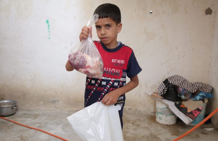 A boy in Gaza, Palestine receives his family's Eid ul-Adha Qurbani meat from Muslim Futures, in 2022