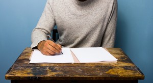 Young man writing at desk