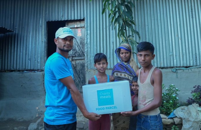 Charity Meals Worker Handing Over the Food Parcel to Needy Family