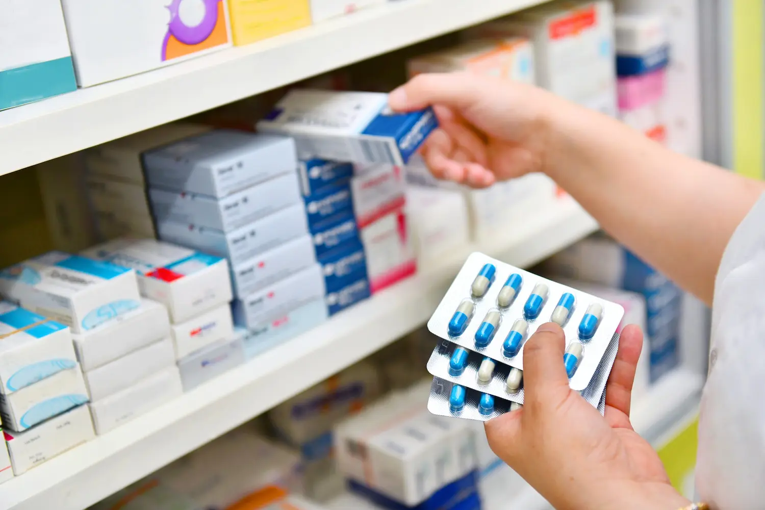 Pharmacy handing tablets to a customer, raising waste concerns.