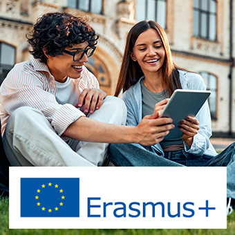 Imagen de un chico y una chica sentados en el césped mirando una tablet