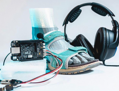 Bodegón compuesto de una sandalia y objetos tecnológicos