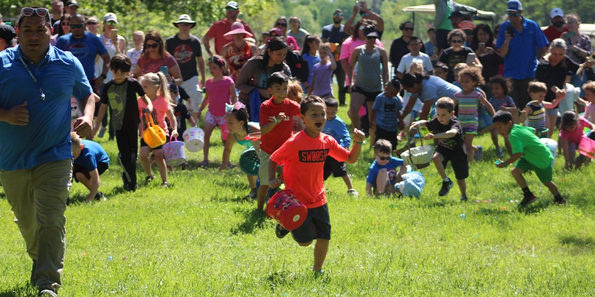 Kids running on the grass to find the easter eggs.