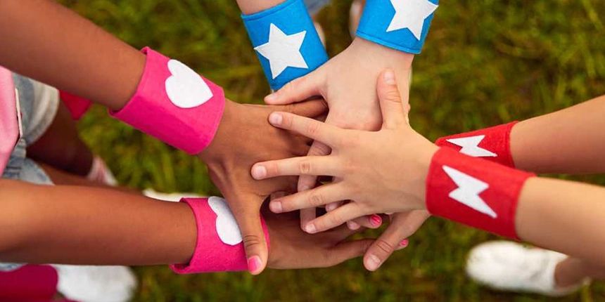 Kids with heroes bracelets on in a huddle. 