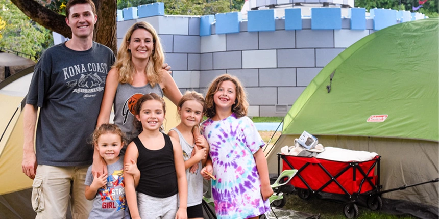 Family with kids posing in front of the castle at Fairytale Town.