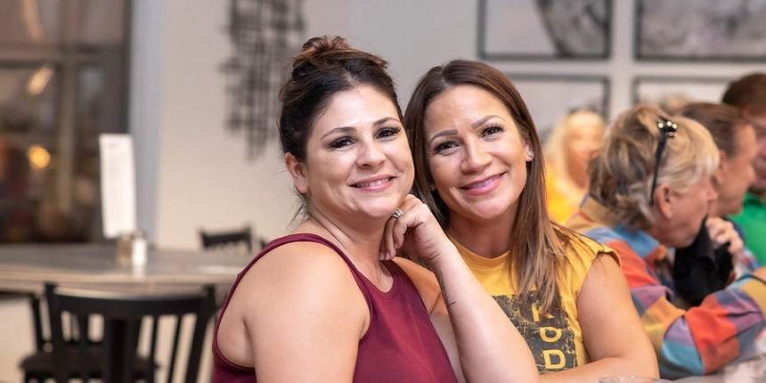 Two women smiling at the camera from the bartop at the Waterfront Grille. 