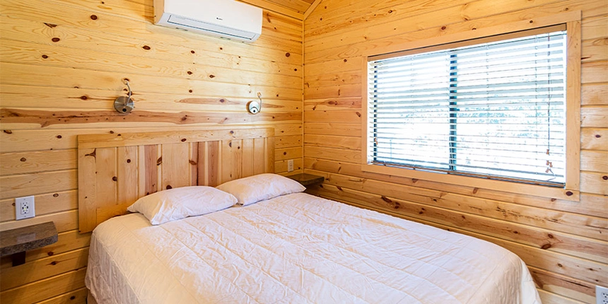 The inside of one of cabins with the bed made nicely. 