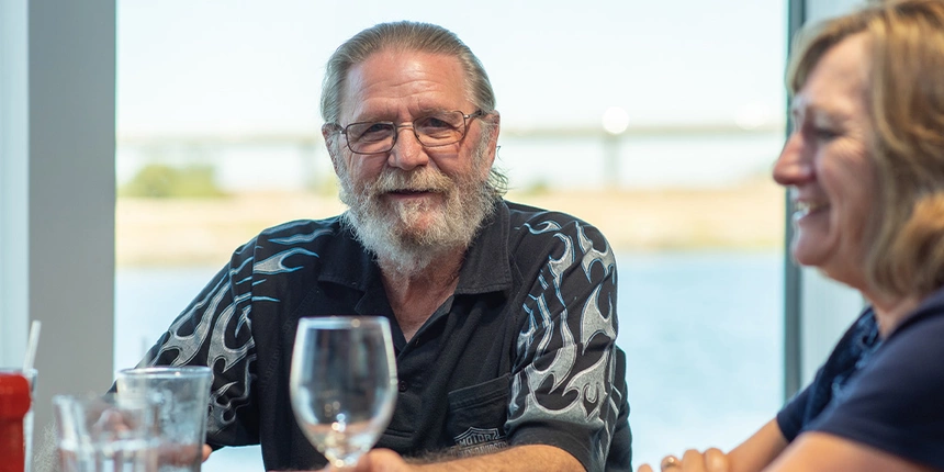 A man at the Waterfront Grille having a meal with his friends and families.