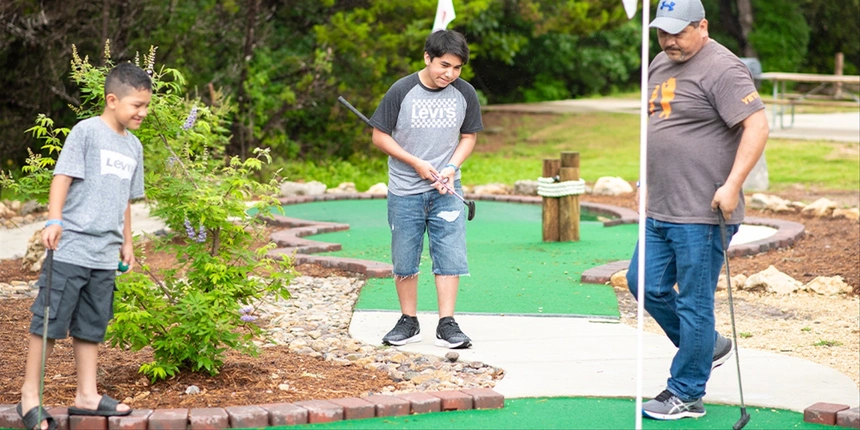 Campers playing mini golf at our Camp-Resort.