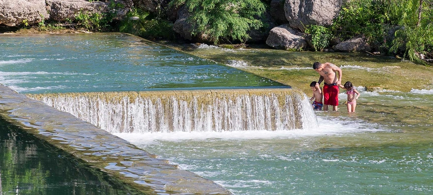 A family playing in the Blanco River.