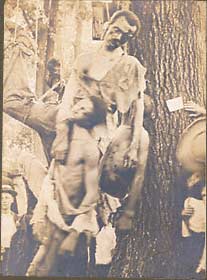 The corpses of five African American males, Nease Gillepsie, John Gillepsie, "Jack" Dillingham, Henry Lee, and George Irwin with onlookers.