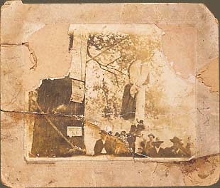 The lynching of Augustus Goodman (?), his body hanging from oak tree that served as a community bulletin board, onlookers. November 4, 1905, Bainbridge, Georgia.