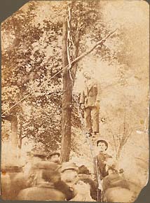The lynching of Charles Mitchell, his body hanging from a tree in a courthouse yard.