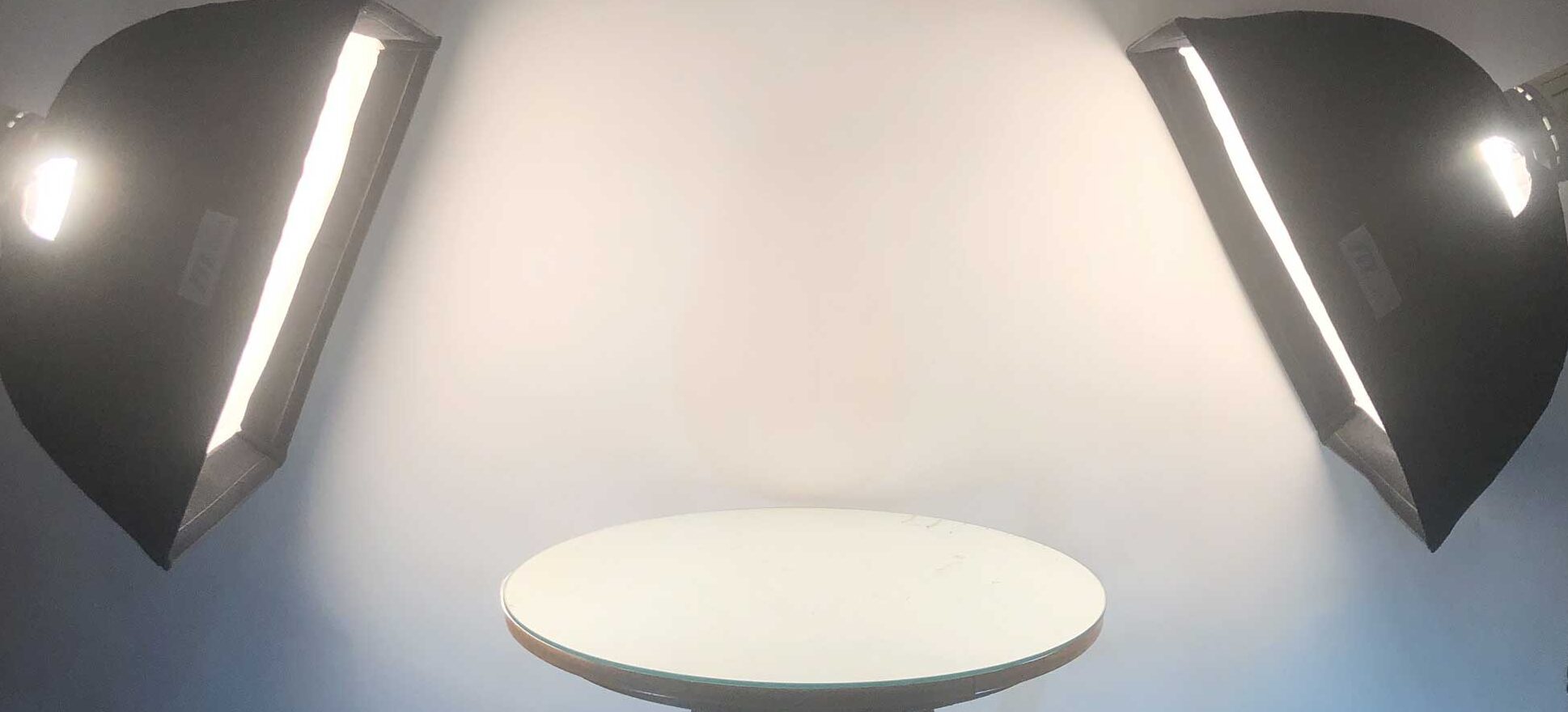 Two photography lights shining on an elevated table.