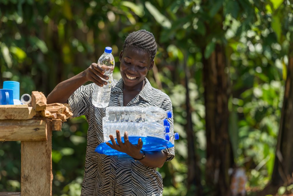 A local Uganda collects water bottles filled with water cleaned by UV radiation
