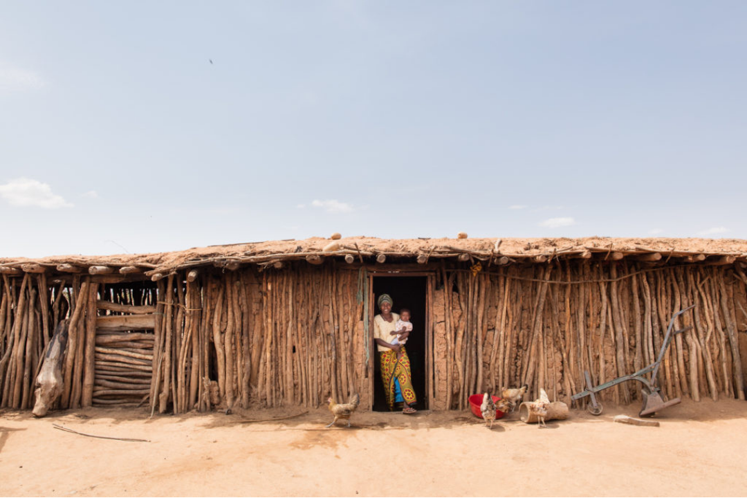 Philp is cradled by his mother as they stand in the doorway of their home