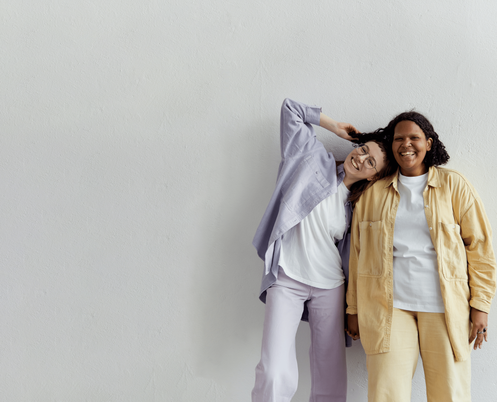 Two friends in pastel colours smiling