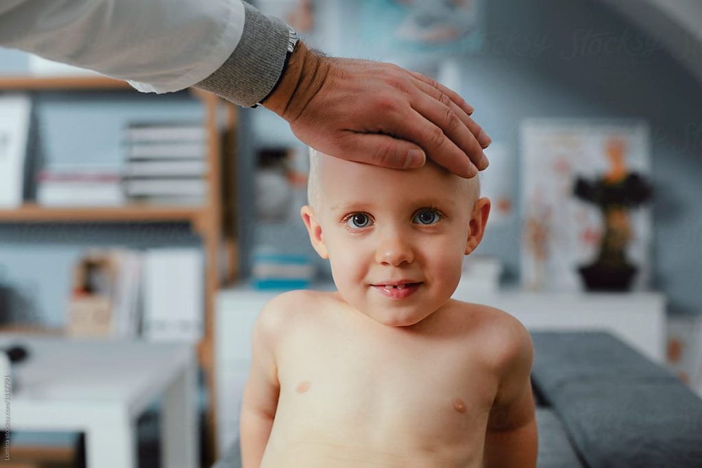 doctor touching young boys head
