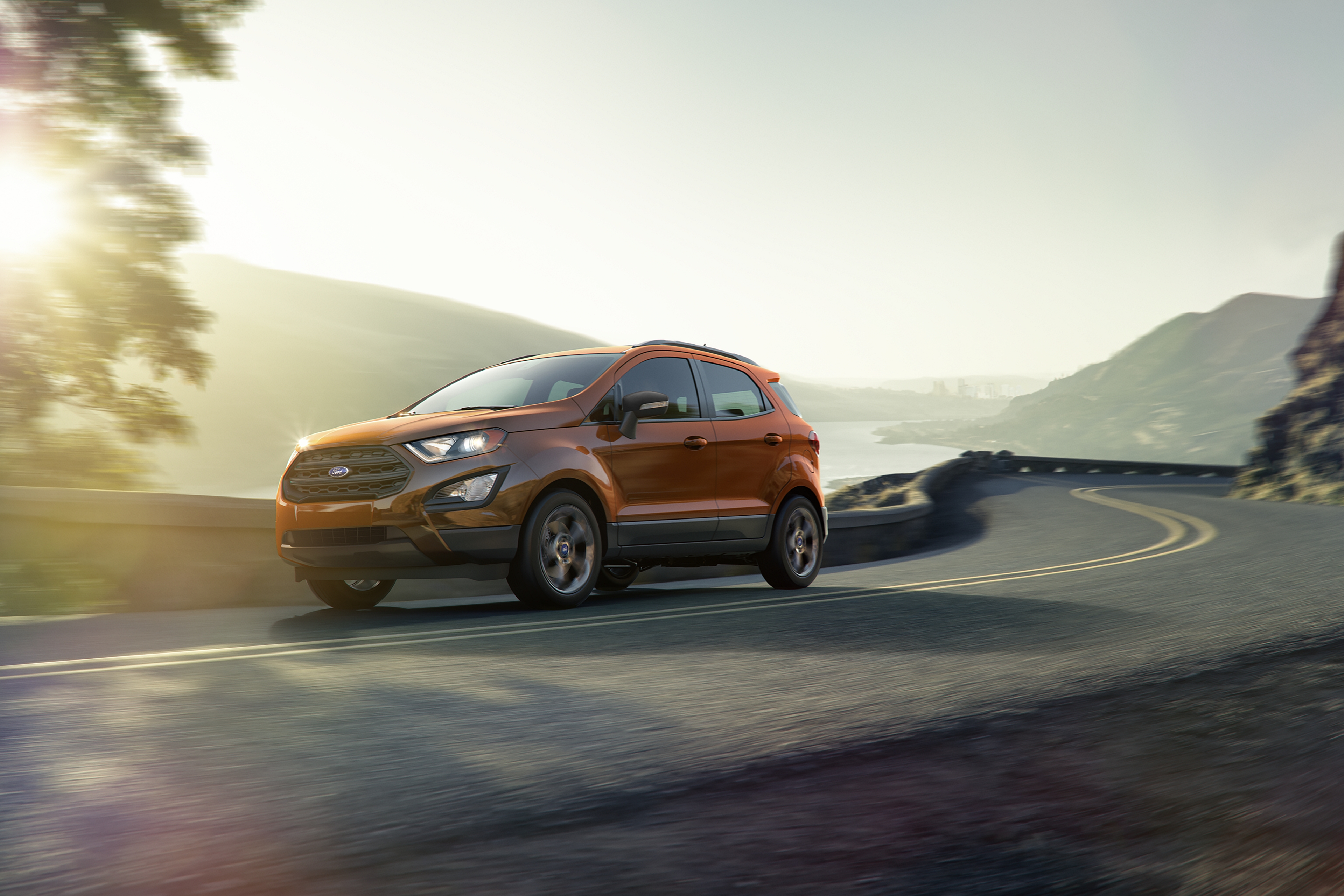 orange 2019 ford ecosport driving along mountain road