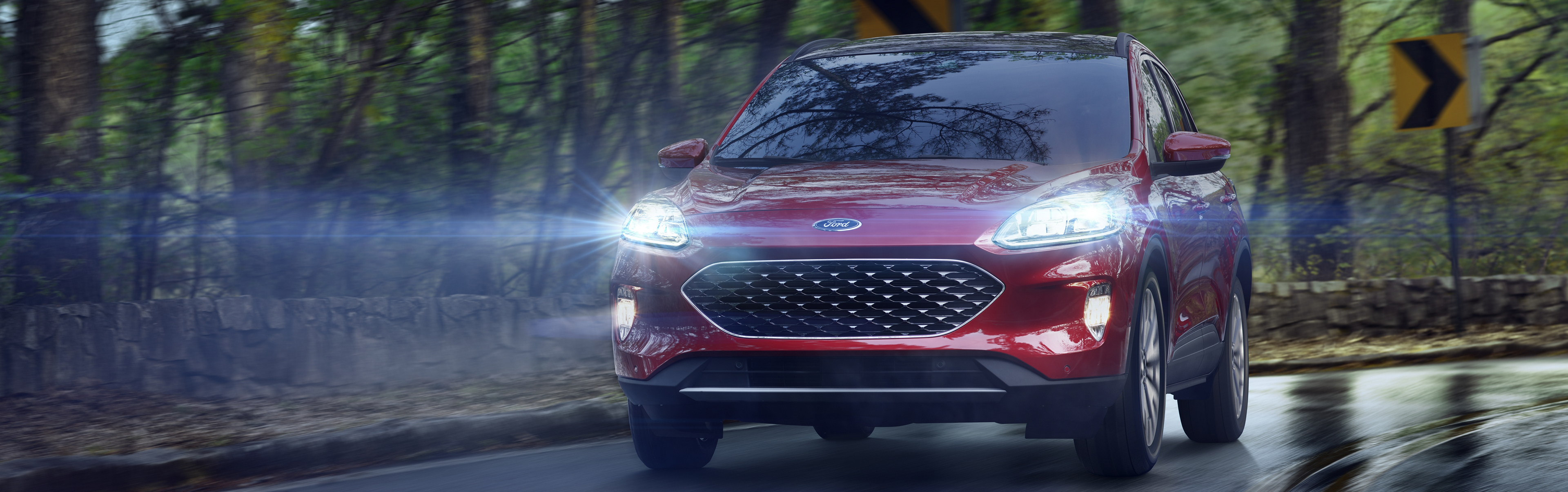 red 2020 ford escape driving through the woods on wet roads