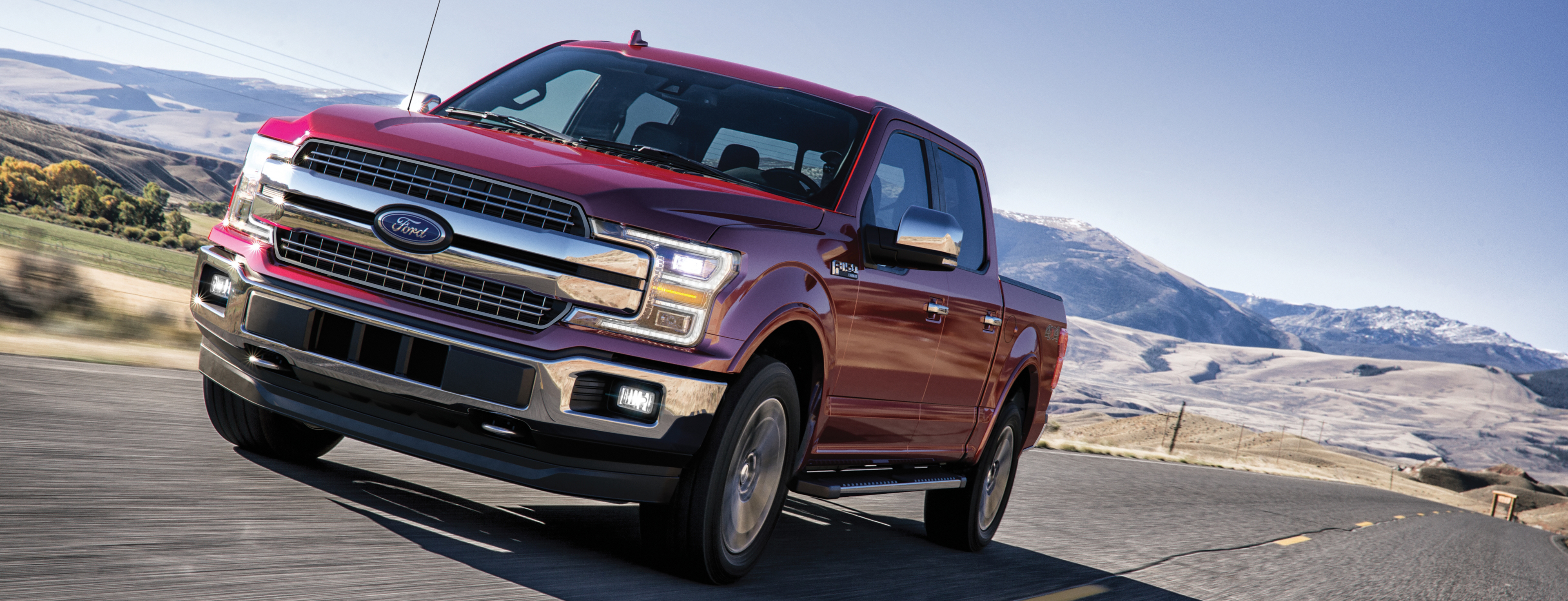 red 2020 ford f-150 driving on a road in the desert