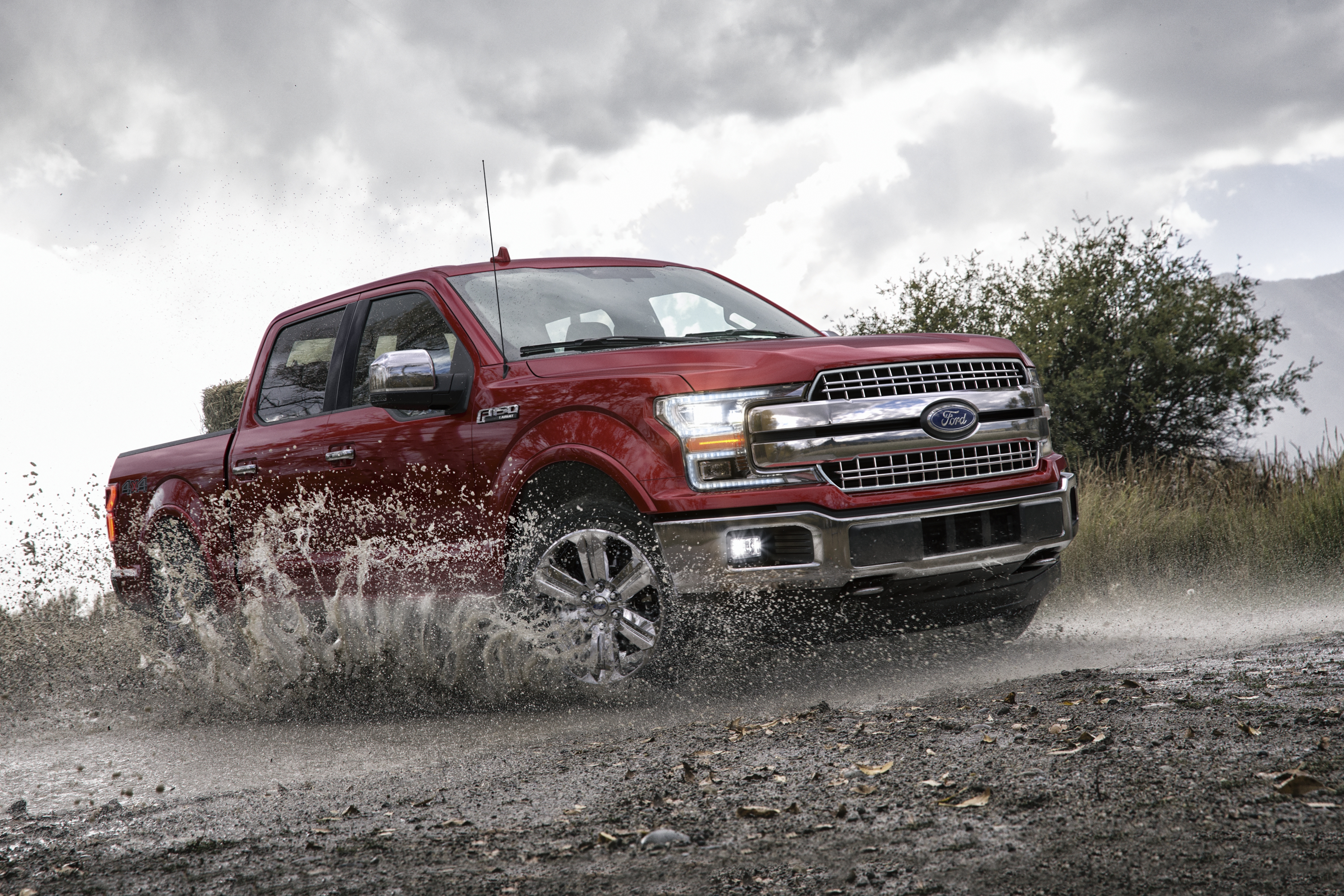 red 2020 ford f-150 driving through mud