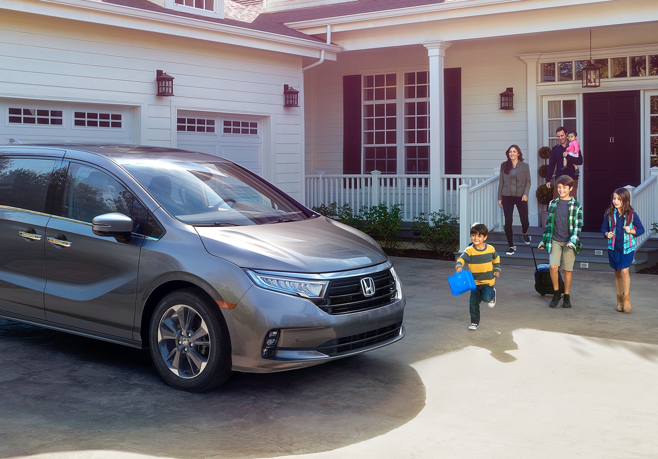 Family getting into a 2023 Honda Odyssey parked in their driveway