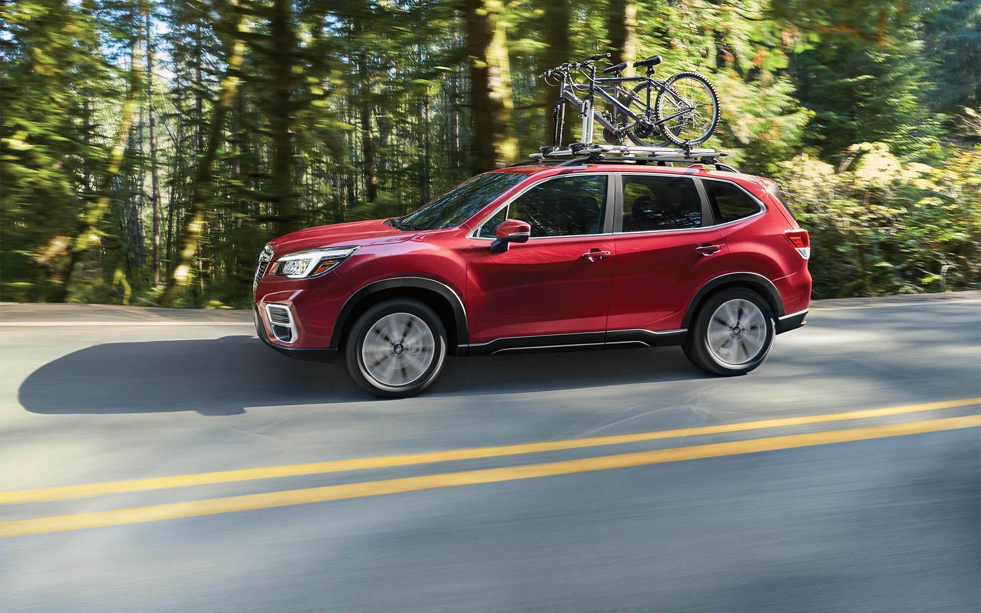 red 2020 subaru forester driving through the woods