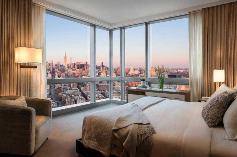 Guestroom with floor-to-ceiling windows and city views.