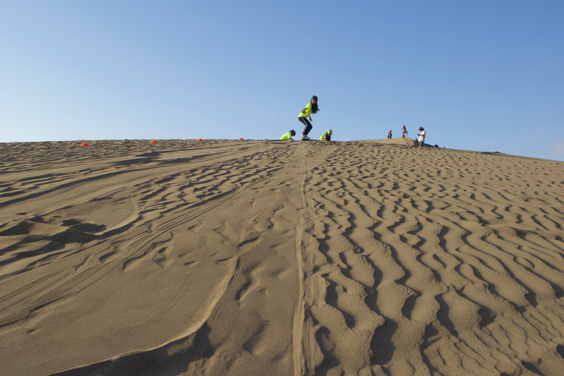 Woman surfs the dunes of Iquique