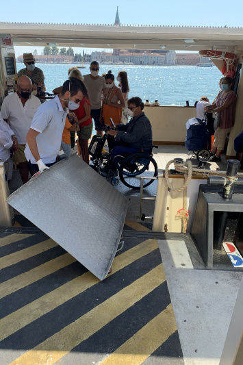 Tour participants use a ramp to enter the Vaporetto and head across the canals