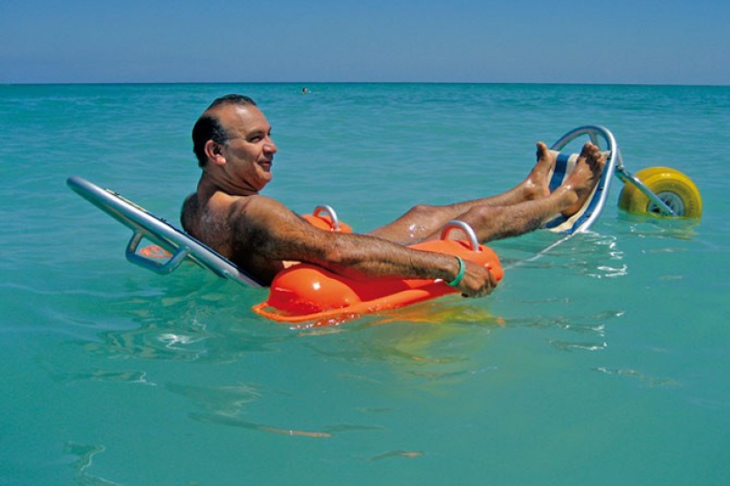 A man enjoys the ocean floating in an amphibious wheelchair