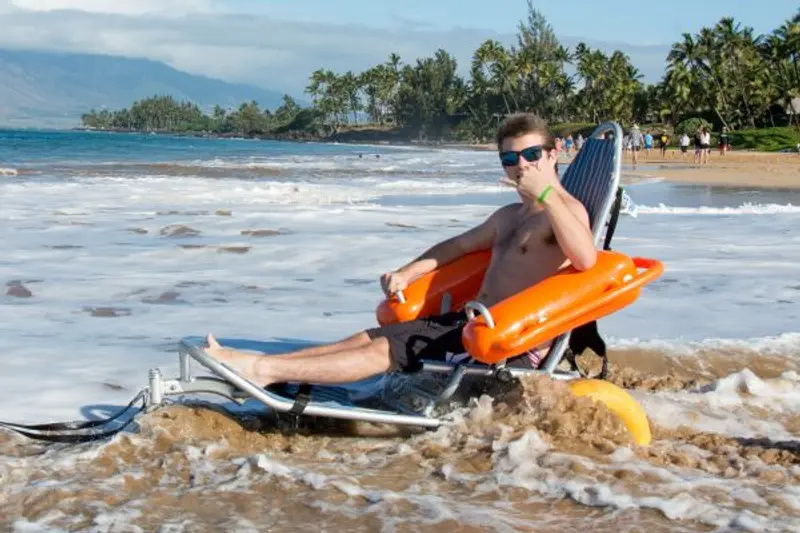 A wheelchair is enjoying the beach on a beach wheelchair