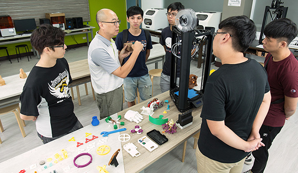 李博明在新設立的「J-Maker實作工坊」教學生3D列印實作內容,桌面上為3D列印作品。