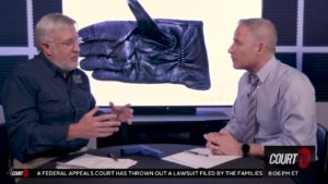 joseph scott morgan and vinnie politan talk with a photo of a glove on a monitor behind them