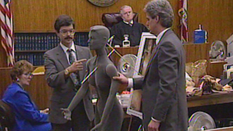 attorneys stand with a dummy model in court.