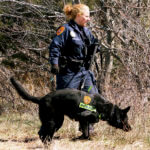 officer and dog search the Gilgo Beach area on New York's Long Island