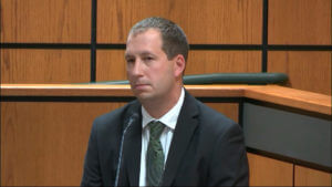 man wearing suit testifies