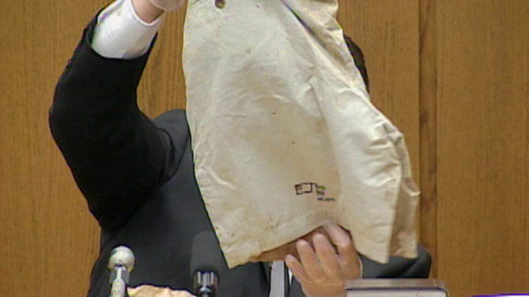 A witness holds a bag on the witness stand