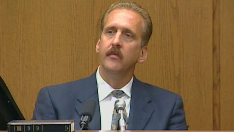 A man looks up as he testifies in court