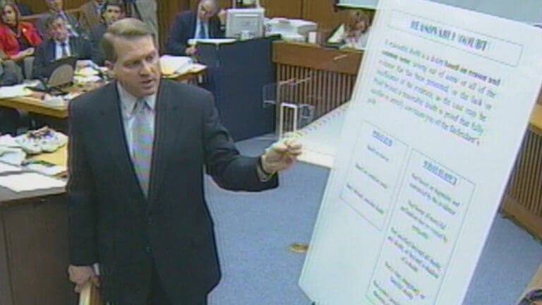 A man points to a large display in court