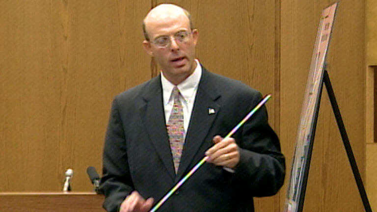 A man holds a pointer in court