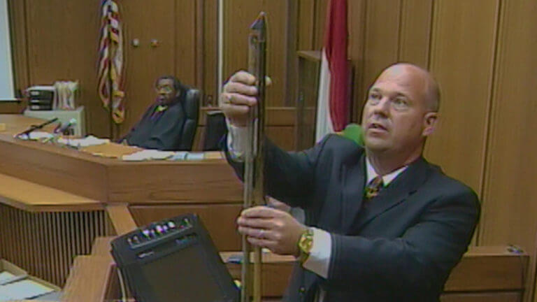 A man holds evidence in front of the jury