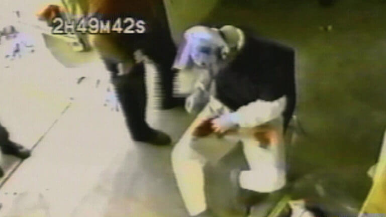 A still from surveillance video shows someone bent over