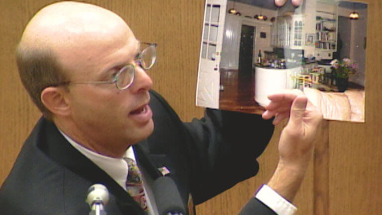 A man holds up a photograph in court