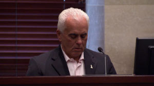 George Anthony looks down while he testifies