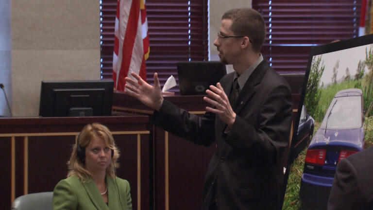 A man holds evidence in front of the jury