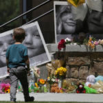 A boy checks out a memorial for Tylee Ryan, 17, and Joshua 